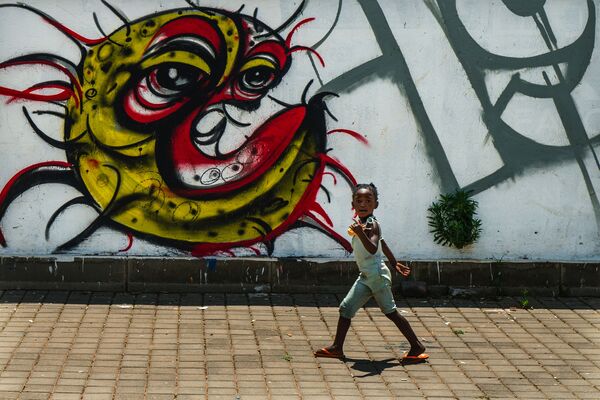 Ребенок у граффити с изображением COVID-19 в Совето, ЮАР - Sputnik Moldova-România