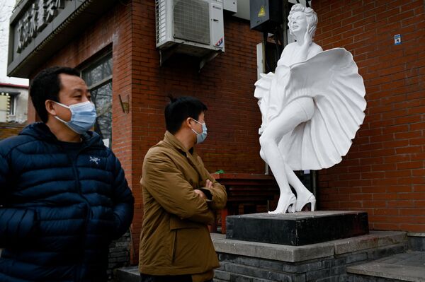 Прохожие у статуи возле магазина на улице в Пекине - Sputnik Молдова