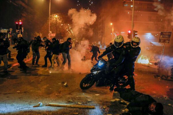 Полицейские на мотоцикле стоят рядом с раненым товарищем во время демонстрации против подавления полицией митингов в Афинах, Греция - Sputnik Молдова