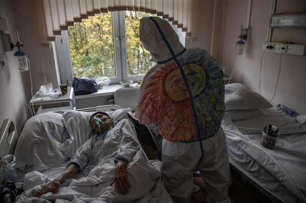 Волонтер ухаживает за больным коронавирусом пациентом Городской клинической больницы № 52 в Москве  - Sputnik Moldova