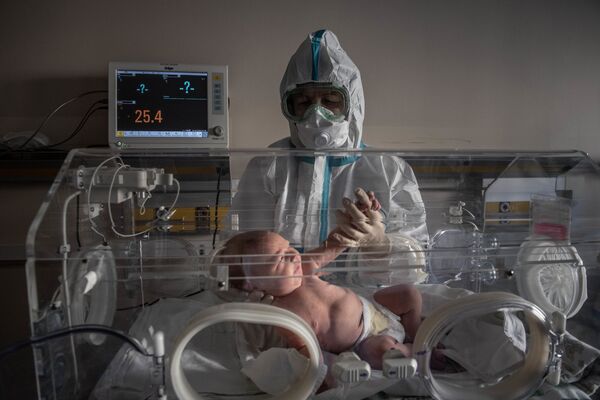 Медицинский работник и новорожденный ребенок в инфекционной больнице № 2 в Москве - Sputnik Moldova
