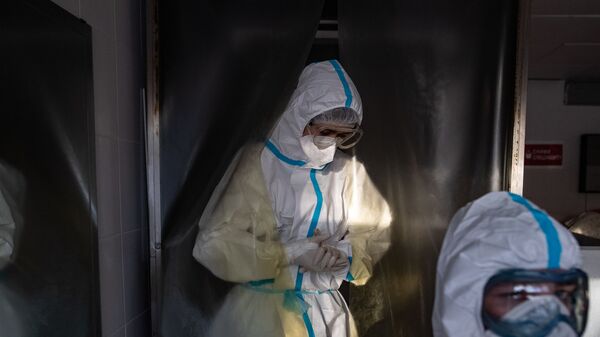 Медик, одетый в СИЗ, проходит через дезинфекционную камеру Московской городской клинической больницы № 15 (больница имени Филатова) - Sputnik Молдова