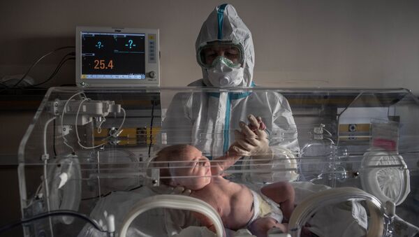 Медицинский работник и новорожденный ребенок в инфекционной больнице № 2 в Москве - Sputnik Moldova-România