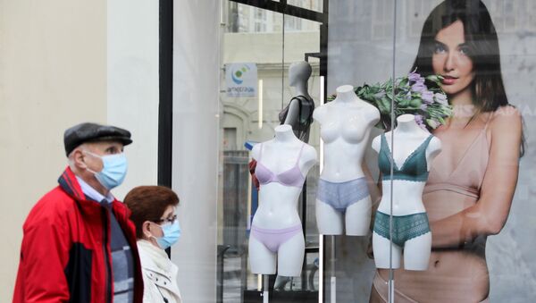 Люди в защитных масках проходят мимо магазина нижнего белья во время карантина в Ницце, Франция - Sputnik Молдова