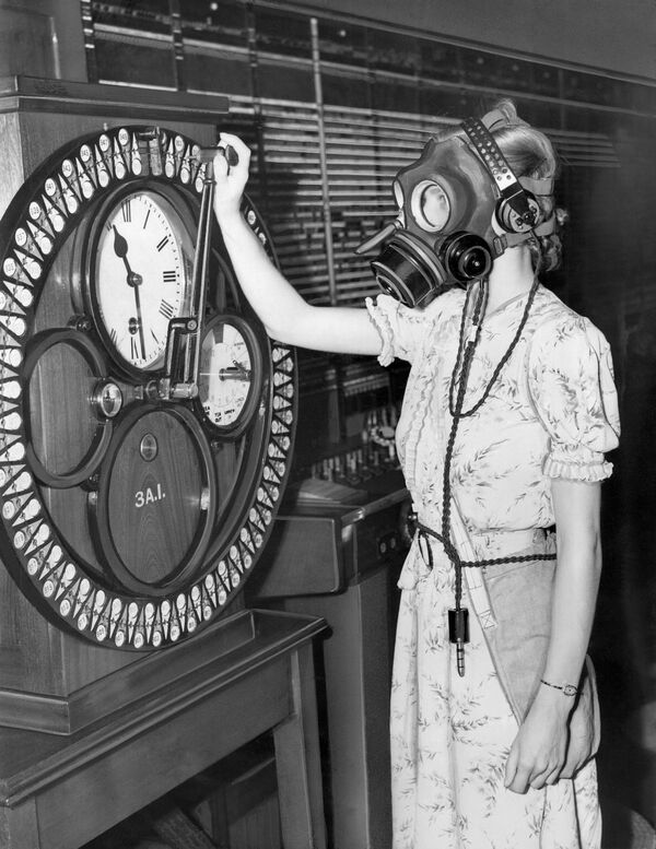 Angajată a unei centrale telefonice din Londra în timpul unei demonstrații a muncii cu masca antigaz, 1938  - Sputnik Moldova