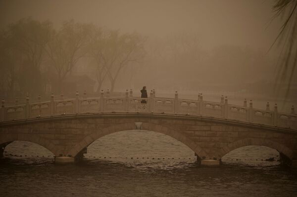 Девушка на мосту через озеро Houhai во время песчаной бури в Пекине  - Sputnik Молдова