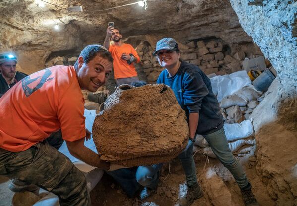 Израильские археологи с древней корзиной, найденной в пещере Мурабаат в Иудейской пустыне недалеко от Мертвого моря - Sputnik Moldova-România