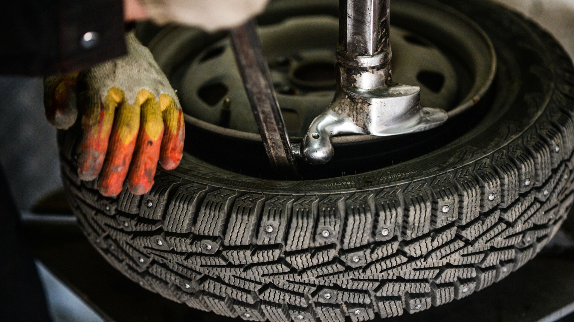 Работник меняет резину на колесе. Архивное фото Работник меняет резину на колесе. Архивное фото - Sputnik Молдова, 1920, 19.03.2021