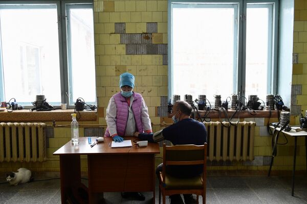 Медсестра измеряет давление у шахтера перед спуском в шахту Мариинского изумрудного прииска в Свердловской области - Sputnik Молдова
