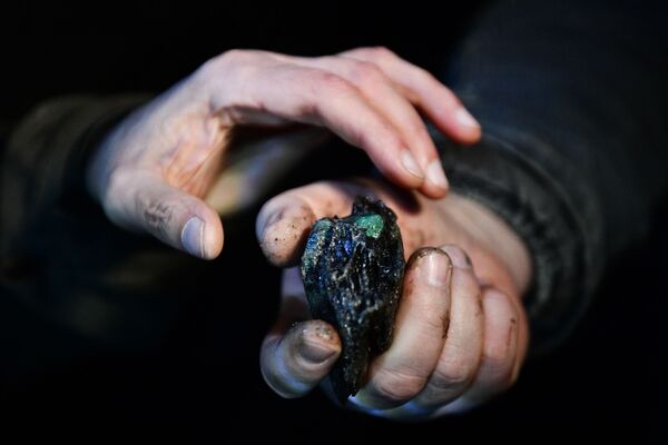Рабочий демонстрирует горную породу с изумрудом в шахте Мариинского изумрудного прииска в Свердловской области - Sputnik Молдова