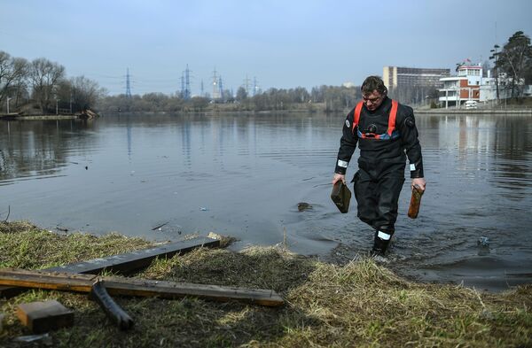 Сотрудник спасательной службы на водных объектах во время очистки дна водоема от мусора в Москве - Sputnik Молдова