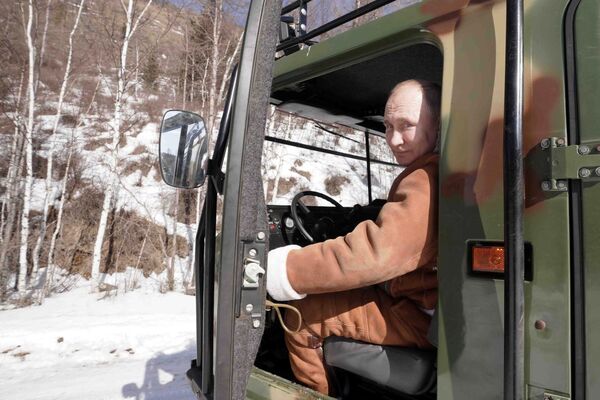 Президент РФ Владимир Путин управляет вездеходом во время прогулки в тайге - Sputnik Moldova-România