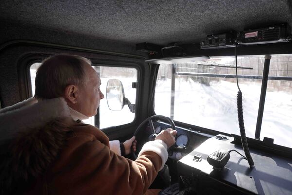 Президент РФ Владимир Путин управляет вездеходом во время прогулки в тайге - Sputnik Moldova-România