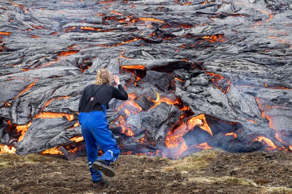 Мужчина смотрит на лаву после извержения ввулкана в Исландии - Sputnik Молдова