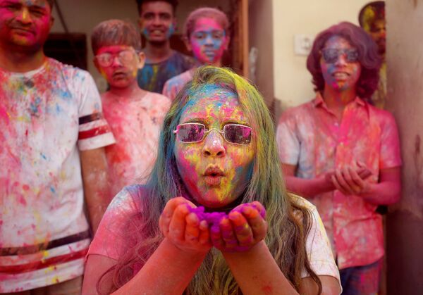 Покрытая цветной пудрой женщина во время празднования фестиваля Холи в Ахмадабаде, Индия - Sputnik Молдова