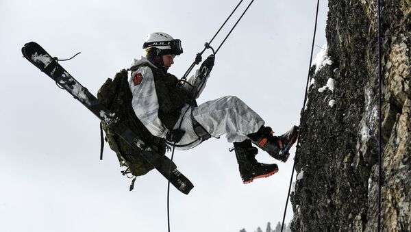 Участница лыжного марш-броска всеармейского конкурса по ски-альпинизму Саянский марш во время спуска по закрепленной веревке на скальном спецучастке в горах Западных Саян - Sputnik Молдова