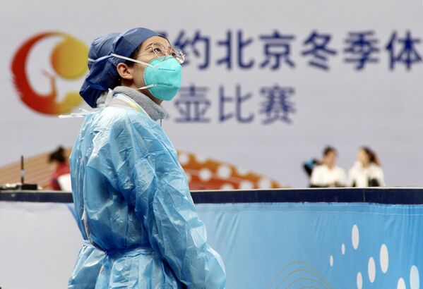 Медик в защитном костюме и маске посещает тестовые соревнования по керлингу в Пекине - Sputnik Молдова