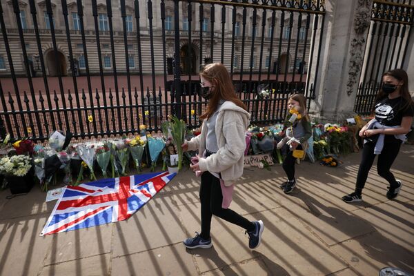 Дети несут цветы к Букингемскому дворцу после известия о кончине принца Филиппа - Sputnik Молдова