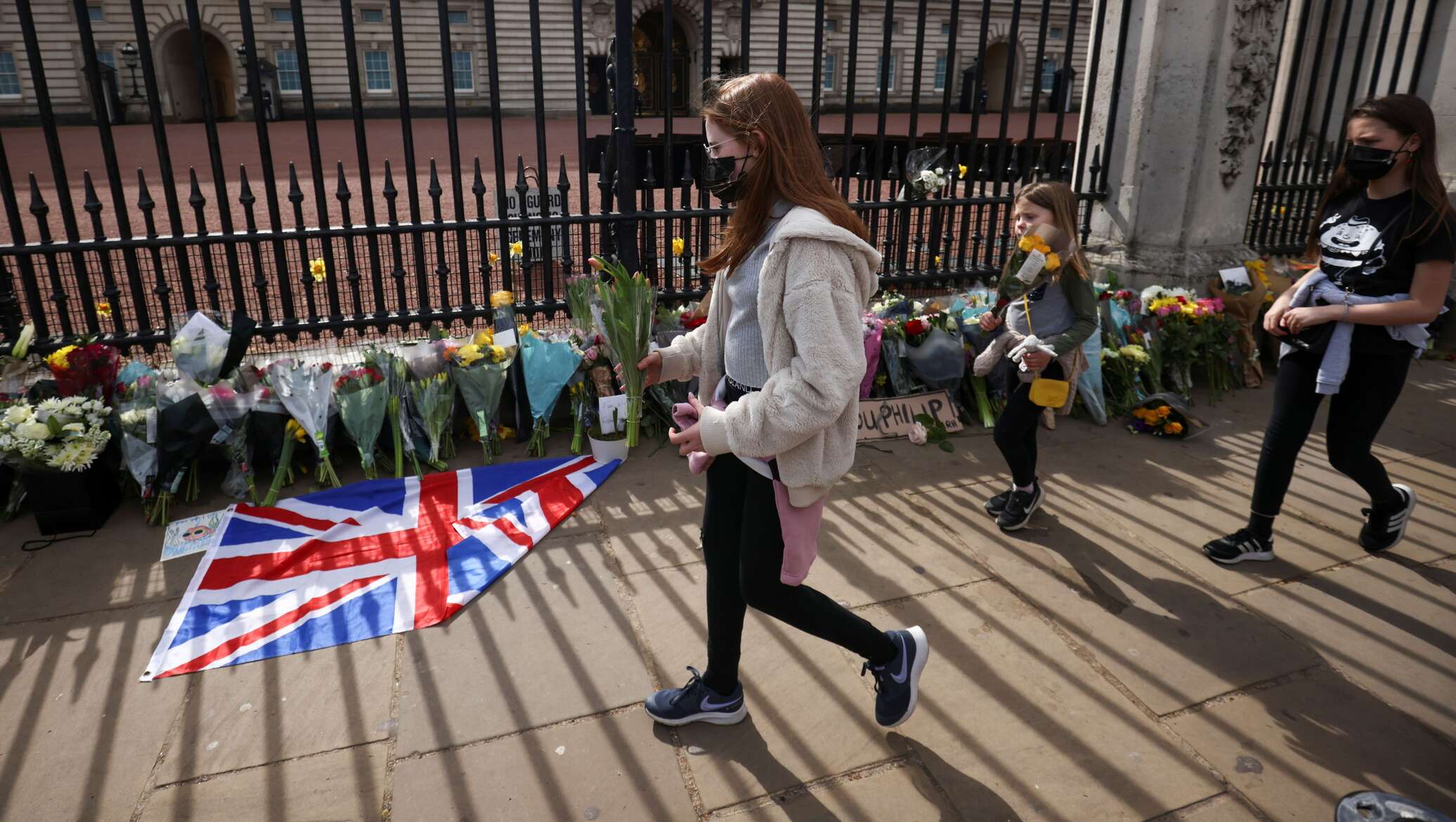 В лондоне приспустили флаги. Похороны герцога Эдинбургского Филиппа. В Великобритании несут цветы. Похороны в Великобритании у людей. Люди у посольства Великобритании скорбят.
