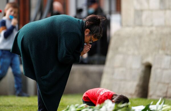 Женщина молится возле Виндзорского замка после того, как было объявлено, что британский принц Филипп умер - Sputnik Молдова