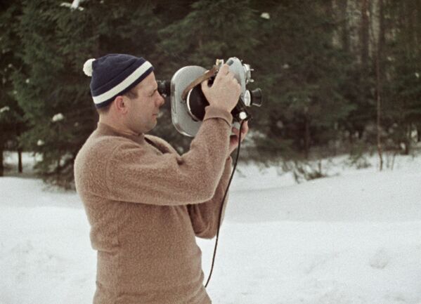 Летчик-космонавт Юрий Гагарин c кинокамерой в зимнем лесу, 1965 год - Sputnik Moldova