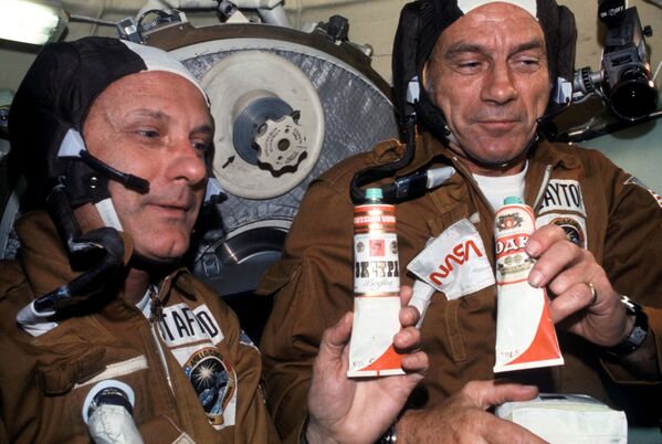 Американские астронавты Томас Стаффорд и Дональд Кент «Дик» Слейтон с тюбиками советской еды в орбитальном модуле Союз - Sputnik Молдова