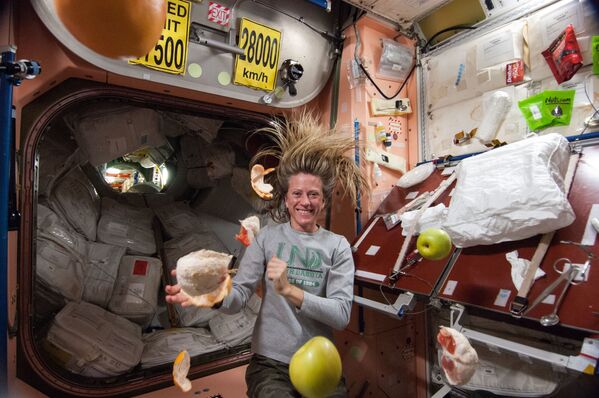 Американский астронавт Карен Найберг с летающими фруктами на МКС  - Sputnik Молдова