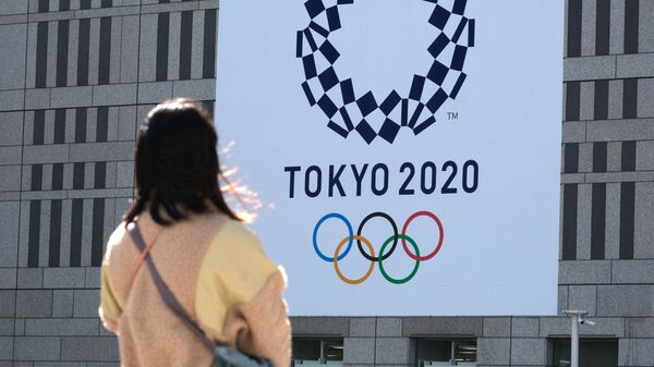 Девушка смотрит на баннер с логотипом Олимпиады в Токио - Sputnik Молдова