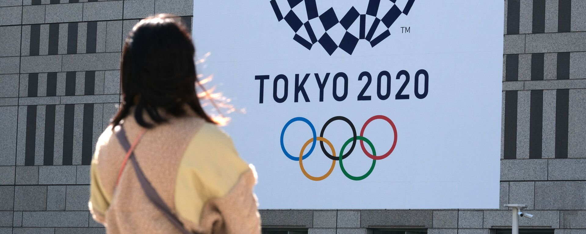 Девушка смотрит на баннер с логотипом Олимпиады в Токио - Sputnik Молдова, 1920, 08.08.2021
