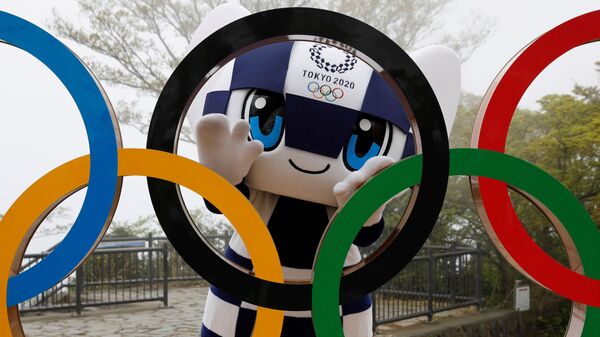 Талисман Летней Олимпиады в Токио Miraitowa позирует сзади Олимпийских колец после мероприятия по случаю 100 дней до Олийписких игр в Токио  - Sputnik Moldova