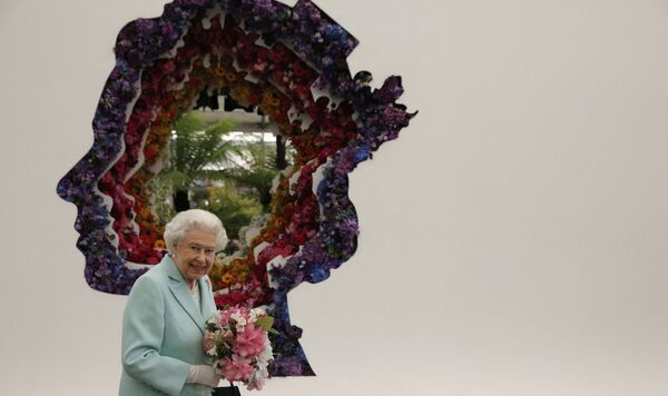 Королева Великобритании Елизавета II рядом со своим портретом во время посещения Цветочной выставки в Челси  - Sputnik Молдова
