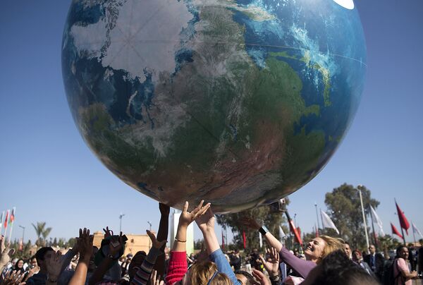 Члены всемирной конференции ООН по вопросам изменения климата с макетом Земли - Sputnik Молдова