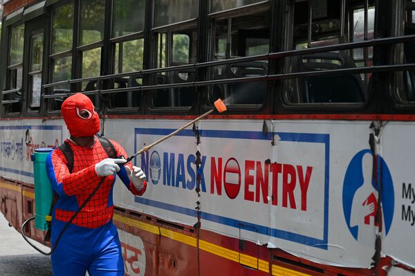 Мужчина в костюме человека-паука дезинфицирует автобус в Мумбаи, Индия - Sputnik Молдова