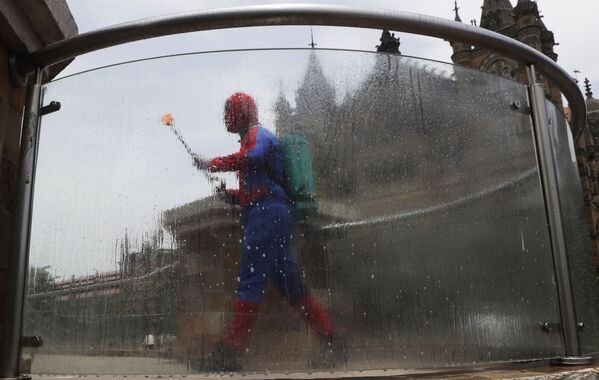 Мужчина в костюме человека-паука дезинфицирует территорию у железнодорожной станции Chhatrapati Shivaji Maharaj Terminus в Мумбаи, Индия - Sputnik Молдова