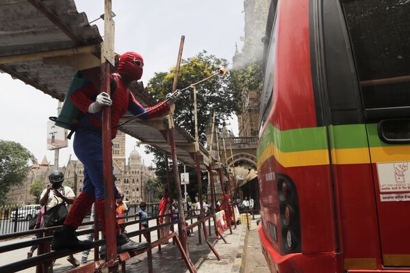 Мужчина в костюме человека-паука дезинфицирует автобус в Мумбаи, Индия - Sputnik Молдова