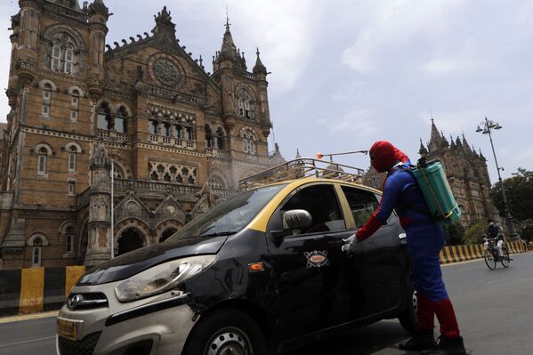 Социальный работник Ашок Курми в костюме человека-паука дезинфицирует такси в Мумбаи, Индия - Sputnik Молдова