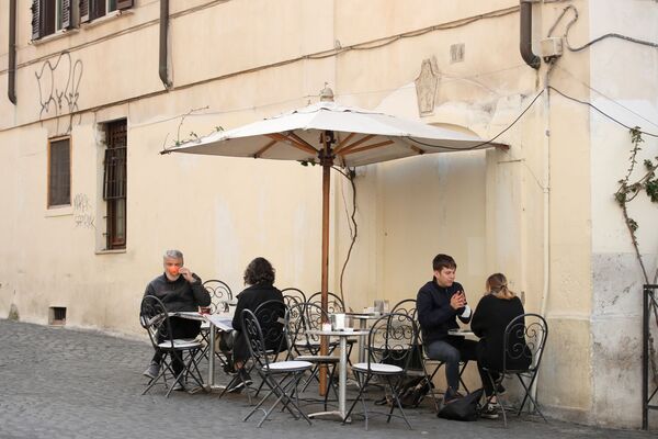 Люди завтракают на открытой веранде бара в Риме - Sputnik Молдова