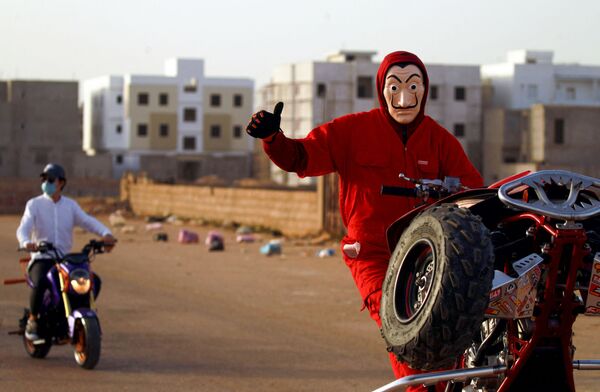 Мужчина маске Дали во время трюка на вездеходе в городе Бенгази на востоке Ливии - Sputnik Moldova-România