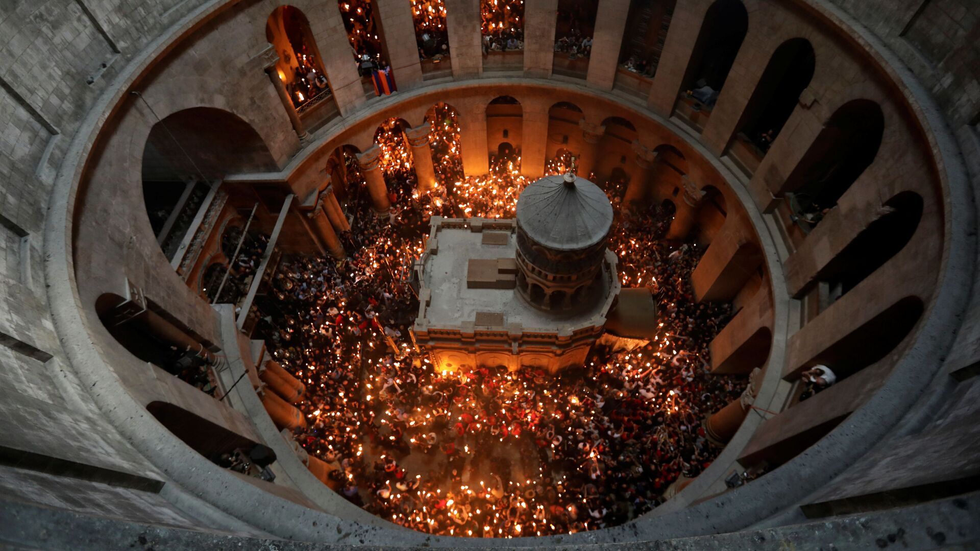 Верующие со свечами во время сошествия благодатного огня в Храм Гроба Господня в Иерусалиме - Sputnik Moldova-România, 1920, 23.04.2022
