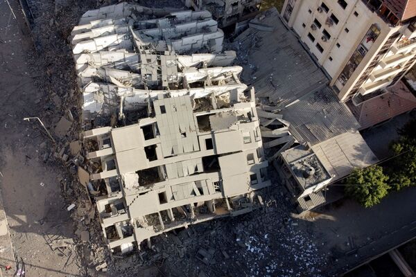 Imaginea cu dronă arată ruinele unei clădiri distruse de atacurile aeriene israeliene pe fondul izbucnirii conflictului israeliano-palestinian din orașul Gaza. - Sputnik Moldova-România