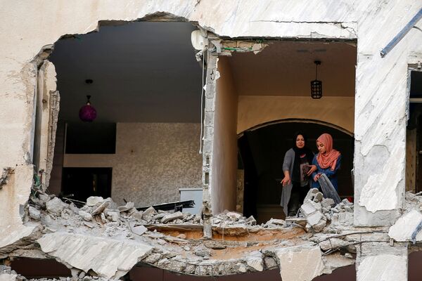 Palestinienii își inspectează casele care a fost avariate de un atac aerian israelian, pe fondul izbucnirii conflictului israeliano-palestinian din orașul Gaza. - Sputnik Moldova-România