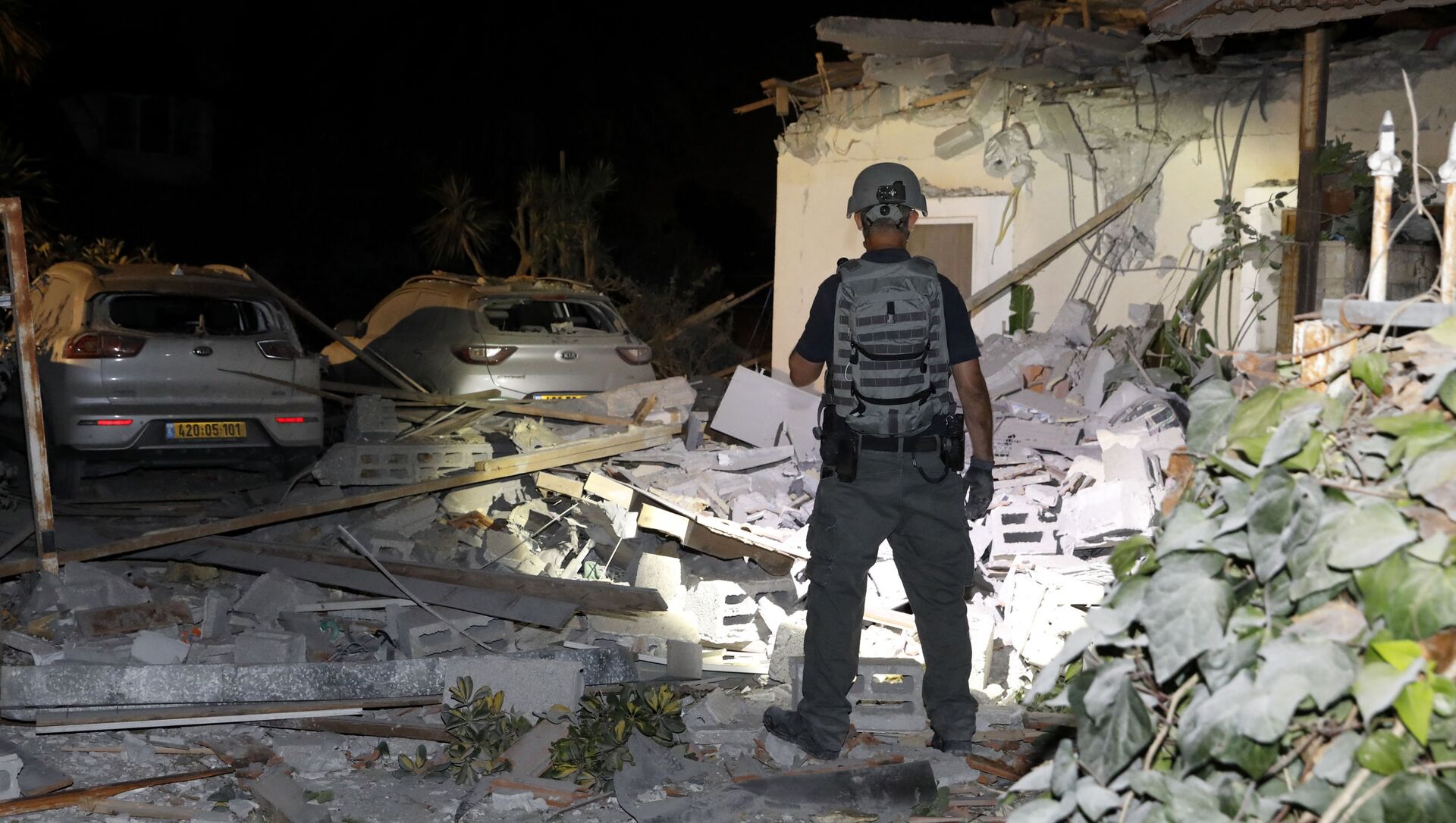 Офицер службы безопасности Израиля осматривает повреждения дома в Йехуде, недалеко от Тель-Авива - Sputnik Молдова, 1920, 14.05.2021