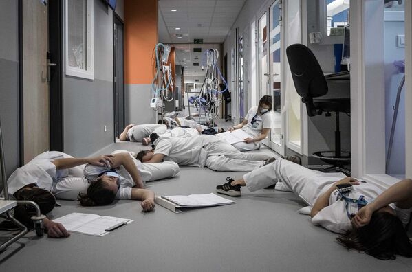 Медсестры и медперсонал лежат на полу в отделении интенсивной терапии во время демонстрации в Международный день медсестер и ухода в больнице Mont Legia в Льеже, Бельгия - Sputnik Молдова
