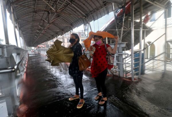 Женщины прячутся под навесом во время циклона в Мумбаи  - Sputnik Молдова