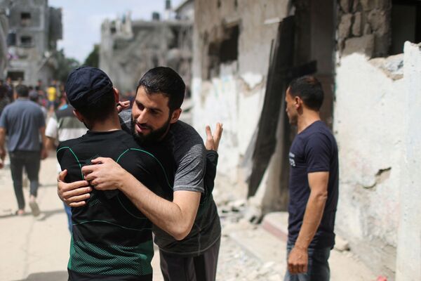 Palestinienii se îmbrățișează reciproc după ce s-au întors la casele lor distruse după armistițiul dintre Israel și Hamas din Beit Hanoun - Sputnik Moldova-România