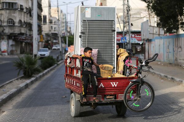 Băiat palestinian călărind o ricșă auto cu bunurile familiei sale în Gaza - Sputnik Moldova-România