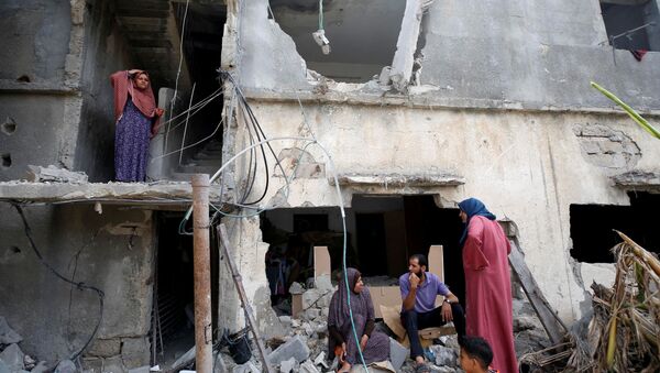 Палестинцы после возвращения в свой разрушенный дом после перемирия между Израилем и ХАМАС в Бейт-Хануне - Sputnik Молдова
