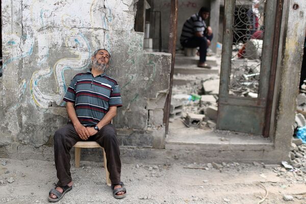 Un palestinian se odihnește după ce s-a întors la casa sa în ruină după armistițiu între Israel și Hamas în Beit Hanoun, în nordul Fâșiei Gaza - Sputnik Moldova-România