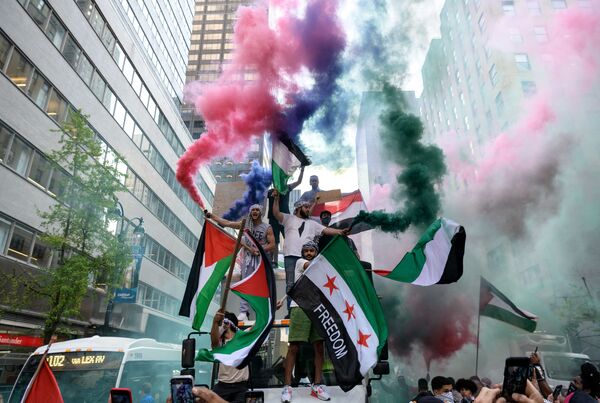 Демонстранты держат палестинский и сирийский флаги в поддержку Палестины в центре Манхэттена - Sputnik Молдова