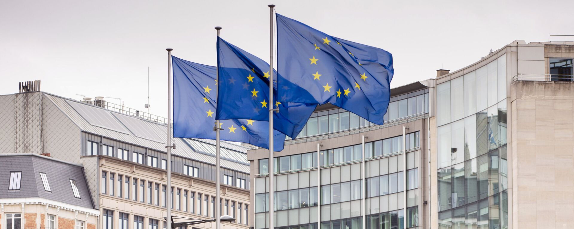 European Union flags flap in the wind as two gardeners work on the outside of EU headquarters in Brussels, Wednesday, 11 September 2019.  - Sputnik Moldova-România, 1920, 24.05.2021
